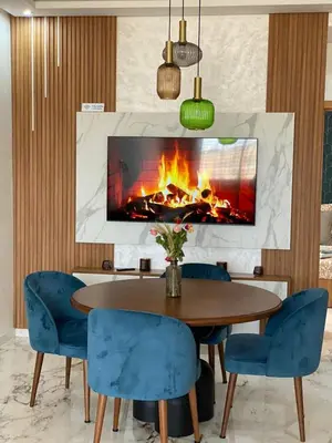 a dining room with a fireplace and a table and chairs at Fun and Sun - Appartement de luxe - Dahomey Beach - Bouznika in Bouznika