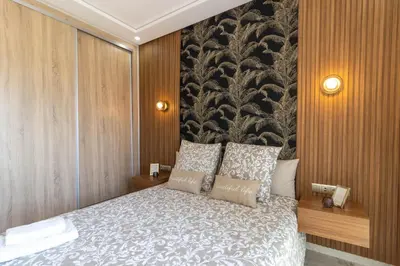 a bedroom with a bed with a black and white blanket at Fun and Sun - Appartement de luxe - Dahomey Beach - Bouznika in Bouznika