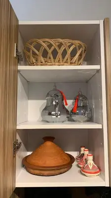 a cabinet with a tea pot and other items in it at Modern apartment centrally located Parc Beach in Mohammedia