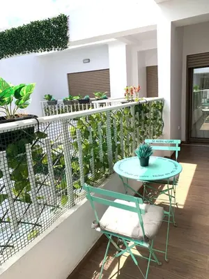 a balcony with a table and chairs and plants at Modern apartment centrally located Parc Beach in Mohammedia
