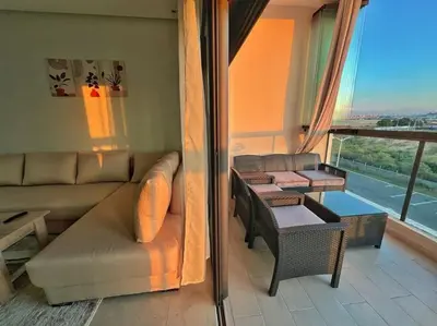 a living room with a couch and a window at Séjour Chic - Appartement Moderne avec Piscine in Bouznika