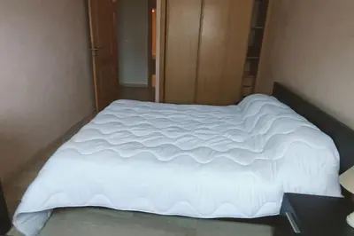 a large white bed in a small room at Sun Palace Palage des Sablettes D5 in Mohammedia