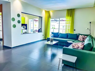 a living room with a blue couch and a table at Premium Appartement vue panoramique mer et piscine in Casablanca