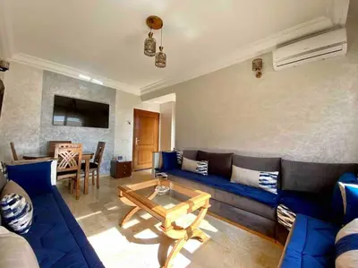 a living room with a blue couch and a table at Sweet Home in Casablanca