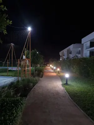 a walking path at night with lights on it at Appartement - Dar Bouazza in Dar Bouazza