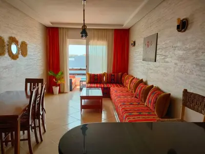 a living room with a couch and a table at Appartement Sidi Rahal à Garden beach2 in Sidi Rahal