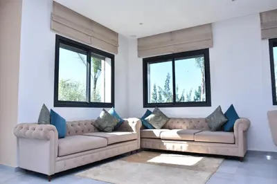 a living room with two couches and two windows at Bens White House in AÃ¯n el Ksob