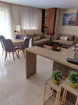 a living room with a couch and a table and chairs at charmant studio en plein cœur de maarif in Casablanca