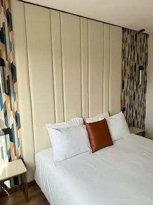a bed with white sheets and a red pillow on it at APPARTEMENT LUXUEUX 29 neuf avec terrasse in Casablanca