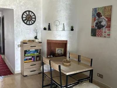 a dining room with a table and a fireplace at Appartement haut standing près de la Plage in Skhirat