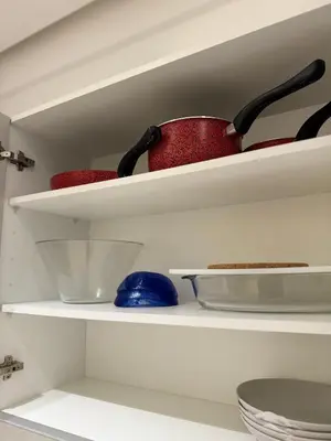 a white shelf with two bowls and a red pot at Presidential living princess in Casablanca