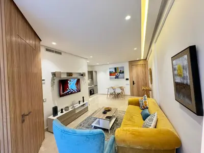 a living room with a yellow couch and blue chairs at Presidential living princess in Casablanca