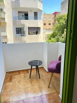 a room with a table and a chair on a balcony at Grenn appt in Rabat