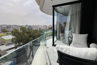 a balcony with a white chair and a view of a city at Le studio in Casablanca