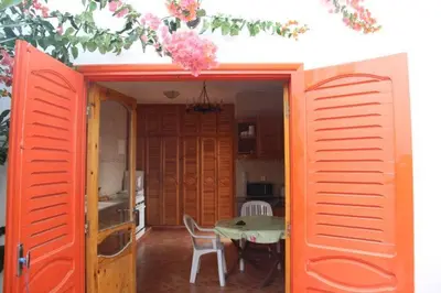 a room with an orange door and a table in a kitchen at Maison d'hôte sur la Plage de Bouznika in Bouznika