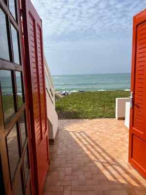 an open door to a beach with the ocean at Maison d'hôte sur la Plage de Bouznika in Bouznika