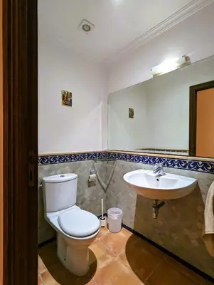 a bathroom with a toilet and a sink at Appartement de plain-pied, piscine et mer in Bouznika