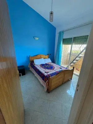 a bedroom with a bed in a blue room at Triplex à 5 min de la plage ! in Temara