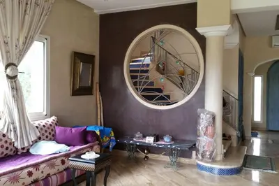 a living room with a purple couch and a round mirror at Villa, piscine sans vis-à-vis in Casablanca