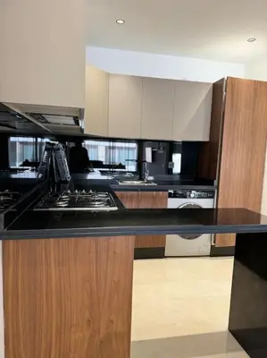 a kitchen with a black counter top and wooden cabinets at Cozy princesse living maarif in Casablanca
