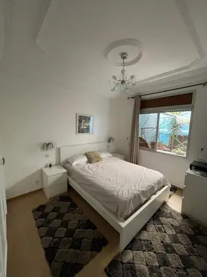 a white bedroom with a bed and a window at La Belle Vue Cosy Apartment in Casablanca