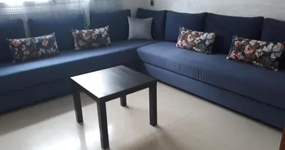 a blue couch with a table in a living room at Appartement Sidi Rahal in Berrechid
