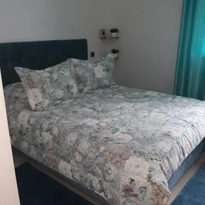 a bed with a blanket and pillows in a bedroom at Appartement Sidi Rahal in Berrechid