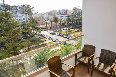 a balcony with two chairs and a view of a street at Le Joyau du Parc in Mohammedia