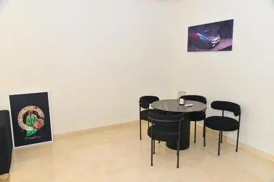 a dining room with a table and black chairs at MOHAMMEDIA Rico Flores in Mohammedia