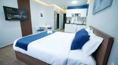 a bedroom with a large bed and a kitchen at Bleu Studio in Rabat