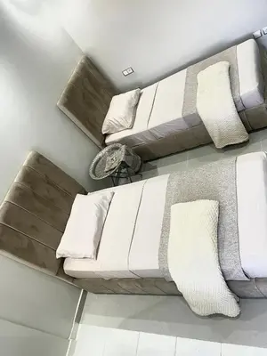a living room with a white couch with pillows at The hidden oasis, steps from the beach and pool in Mohammedia