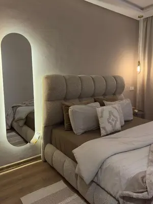 a bedroom with a large bed and a mirror at Beau studio au cœur du parc in Mohammedia