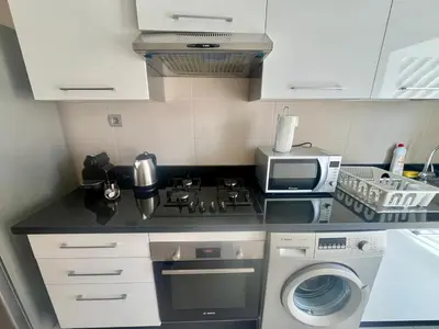 a kitchen with a stove top oven next to a microwave at Zen & Welcoming CFC - Garage & Tramway in Casablanca