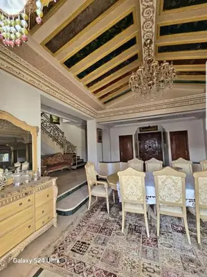 a living room with a table and chairs and a chandelier at Villa de vacances à Hay Riad in Rabat