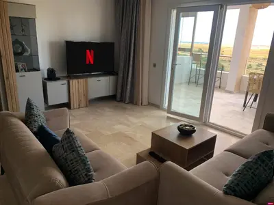a living room with two couches and a tv at Appartement de luxe avec vue sur mer in Bouznika