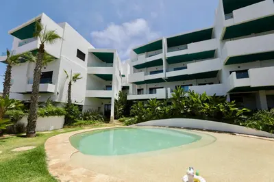 an empty pool in front of a building at Magnifique appartement front mer in Tamaris