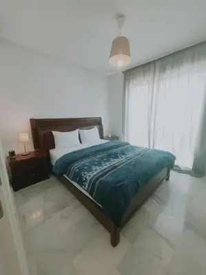 a bedroom with a bed and a large window at Superhote in Nouaceur