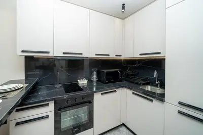 a kitchen with white cabinets and black counter tops at Twenty Four Inn 303 in Casablanca