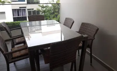 a glass table and chairs on a balcony at Appartement Sidi Rahal in Berrechid