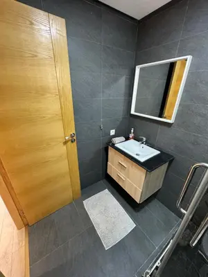a bathroom with a sink and a mirror at Cozy New Apartment in Tamaris in Dar Bouazza