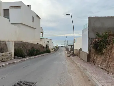 an empty street with a building and a street light at Cozy New Apartment in Tamaris in Dar Bouazza