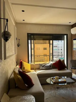 a living room with a couch and a table at Studio meublé neuf Maarif au centre de Casablanca 3 minutes de stade Mohamed V in Casablanca