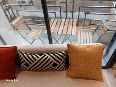 a couch with pillows sitting in front of a window at Studio meublé neuf Maarif au centre de Casablanca 3 minutes de stade Mohamed V in Casablanca