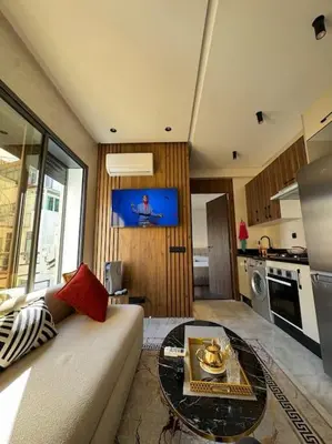 a living room with a couch and a table at Studio meublé neuf Maarif au centre de Casablanca 3 minutes de stade Mohamed V in Casablanca