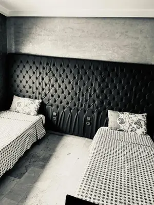 a bedroom with two beds and a large headboard at Ocean Apartments in Casablanca