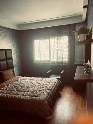 a bedroom with a bed and a table and a window at Ocean Apartments in Casablanca