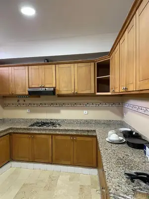 a kitchen with wooden cabinets and granite counter tops at Villa pied dans l'eau skhirat in Skhirat