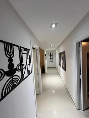 a hallway in a house with white walls and art on the walls at Appartement de Luxe à Bahia Golf Beach Spacieux de 126 m in Bouznika