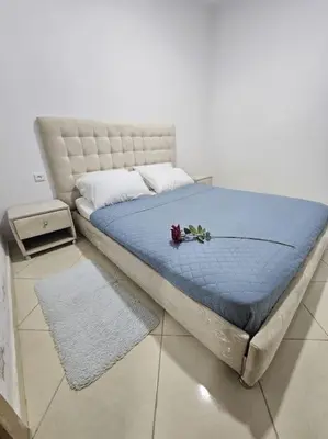 a bed with a blue comforter and flowers on it at Appartement charmant à 5 min de la plage in Skhirat