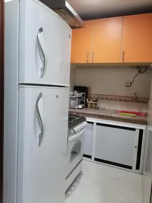 a kitchen with white cabinets and a refrigerator at Studio Avenue de France in Rabat